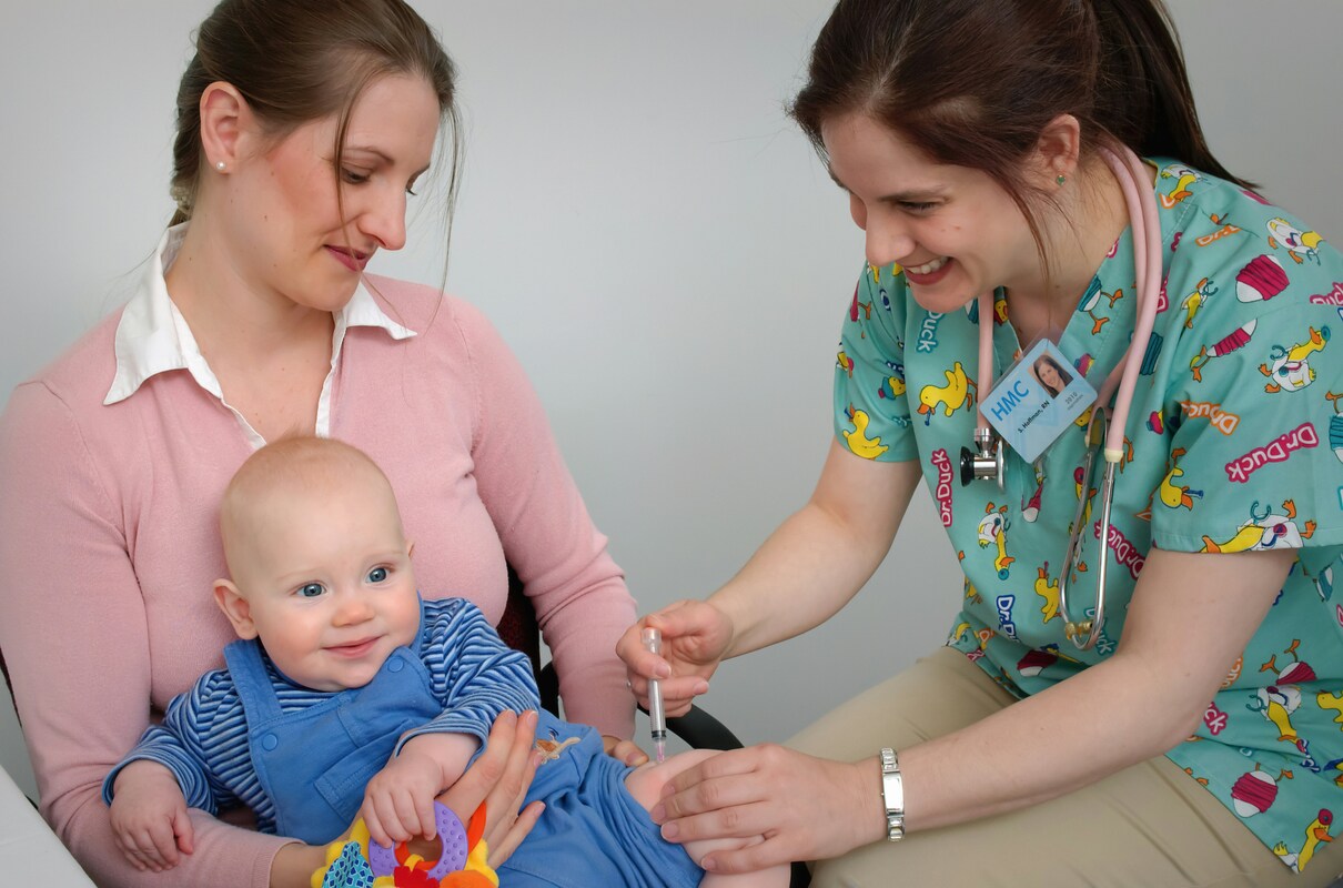 1.1. Ce culori de halate de spital sunt purtate de catre angajati_pediatru facand injectie unui copil