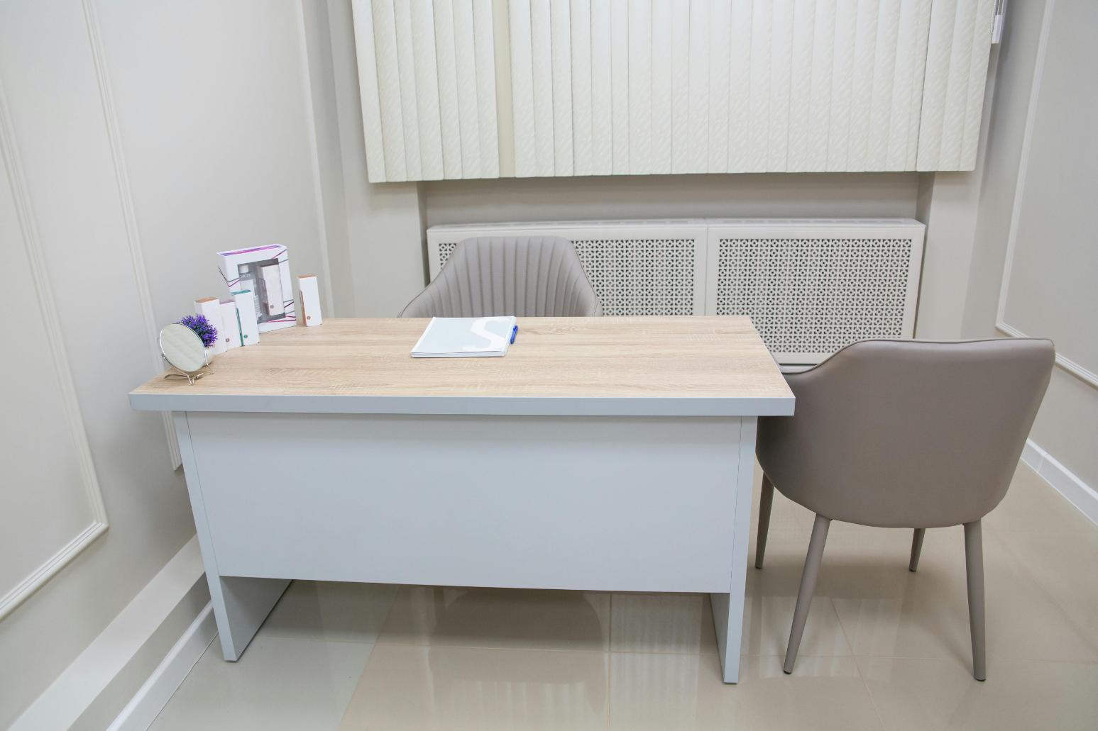 1. Dotare cabinet medical medicină de familie - două scaune gri, masă albă, produse pe masă, podea albă